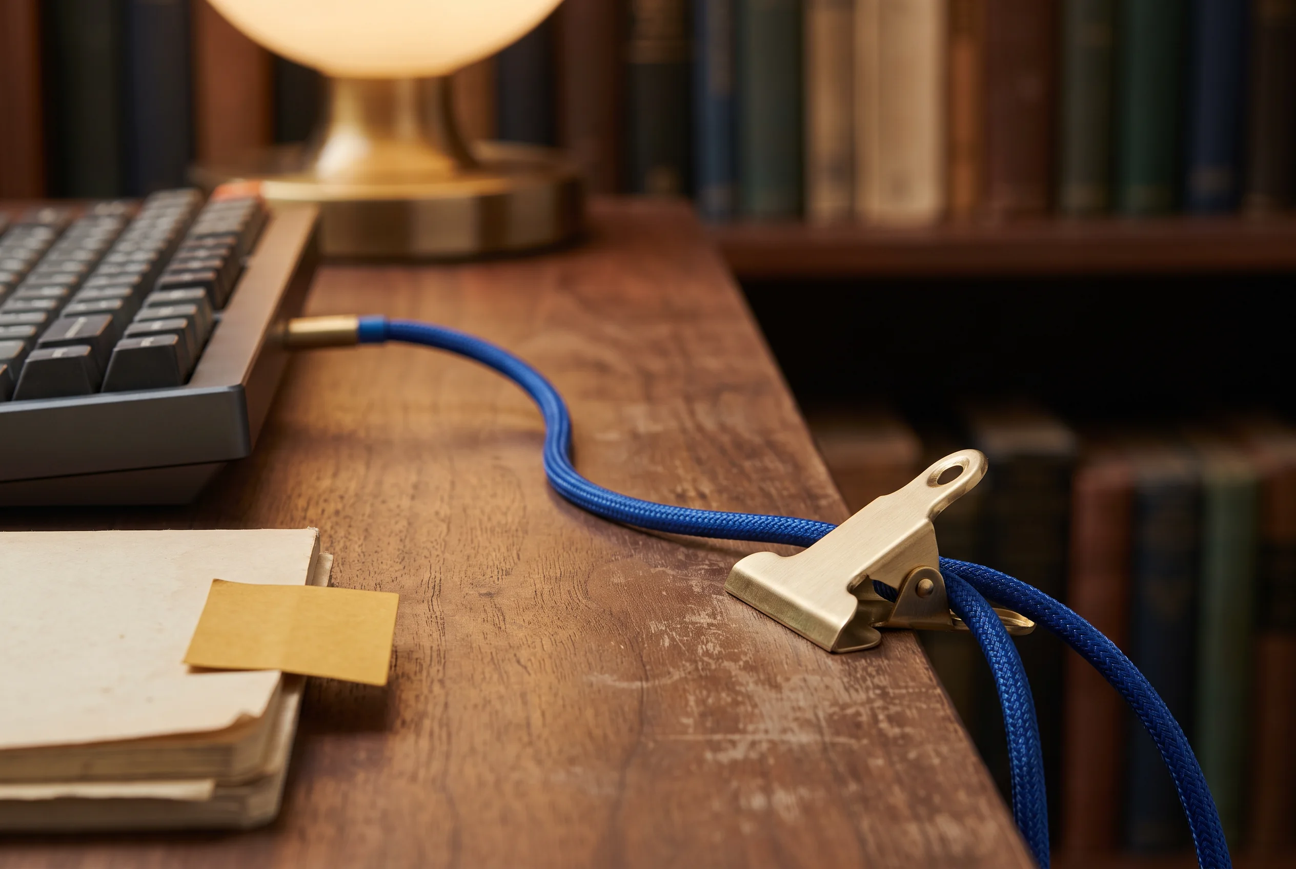 Blue cable and keyboard beside library materials